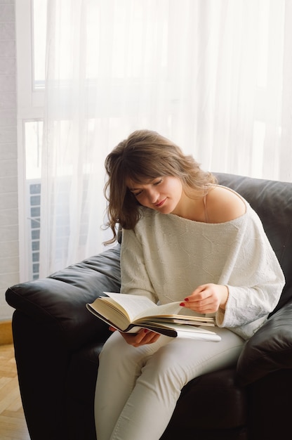 De schoonheids jonge vrouw leest thuis een boek