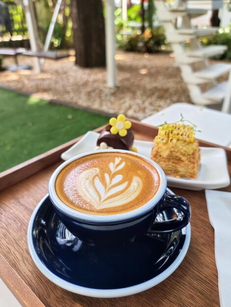 De set voor het serveren van een kop hete latte art koffie met een taartje