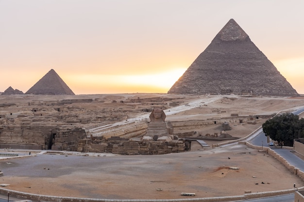 De Sfinx, de Piramide van Khafre en de Piramide van Menkaure in Gizeh bij zonsondergang, Egypte.