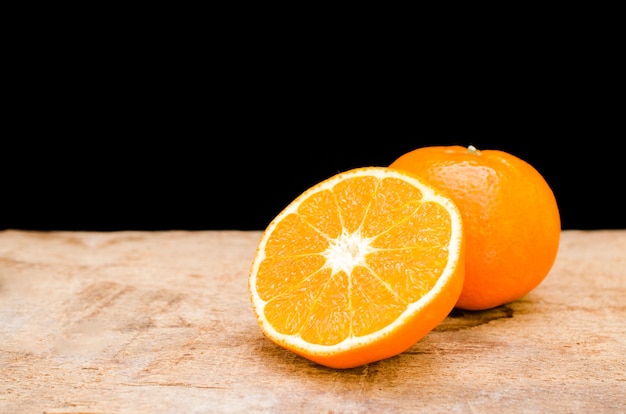 De sinaasappel in tweeën gesneden op een houten tafel