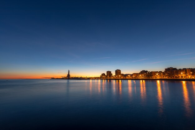 De skyline van Badalona bij schemering