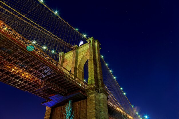 De skyline van Manhattan vanaf de Brooklyn bridge in de schemering met auto's trail.