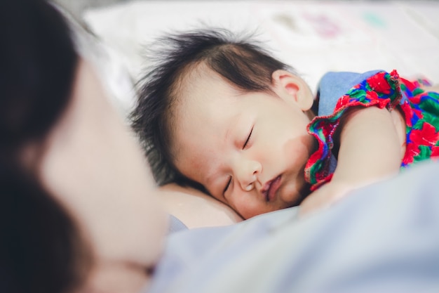 De slaap van het babymeisje met Tante thuis