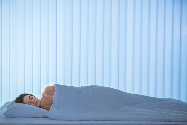 De slapende vrouw lag op het bed. Avond nacht tijd