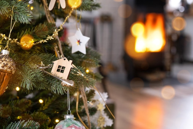 De sleutel van het huis met een sleutelhanger hangt op de kerstboom een cadeau voor Nieuwjaar Kerstmis