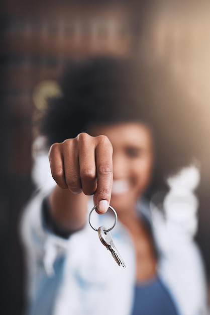 De sleutels tot vrijheid Bijgesneden opname van een jonge vrouw met huissleutels in haar nieuwe huis