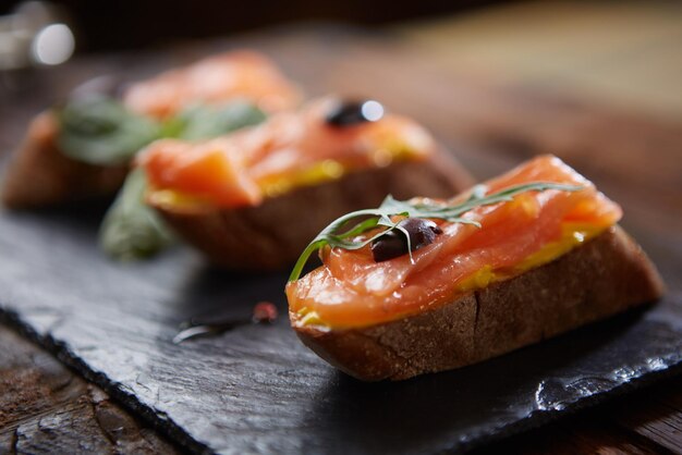 De smakelijke bruschetta met zalm op zwarte steen