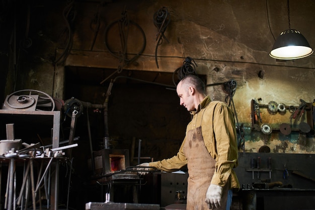 De smid in het productieproces van metalen producten handgemaakt in de werkplaats