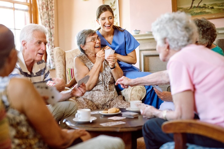 Foto de spanning houdt het spel spannend shot van een groep gelukkige senioren die een kaartspel spelen in hun bejaardentehuis terwijl een verpleegster toekijkt