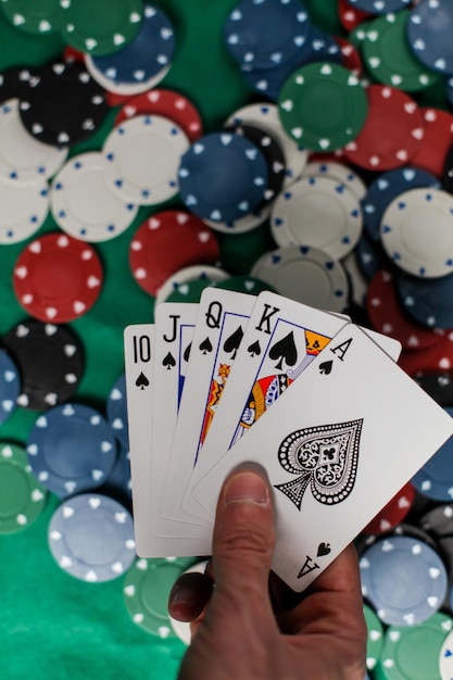 De speler heeft vijf speelkaarten in zijn hand. poker royal flash op kaarten en pokerfiches op casino