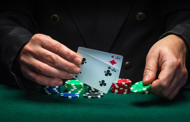 De speler wijst naar de winnende combinatie van één paar in een pokerspel op een groene tafel met fiches en in een club