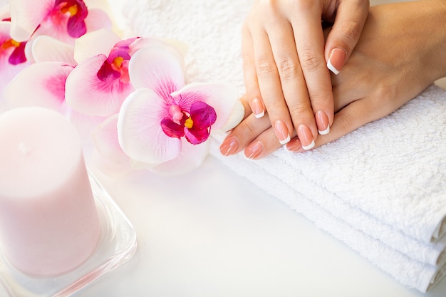 Foto de spijkers van de mooie vrouw met franse manicure, in schoonheidsstudio