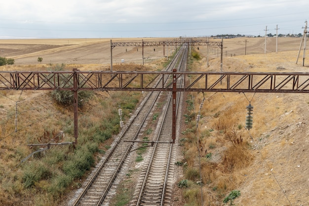 De spoorlijn in de steppe van Kazachstan, uitzicht op de rails vanaf de brug.