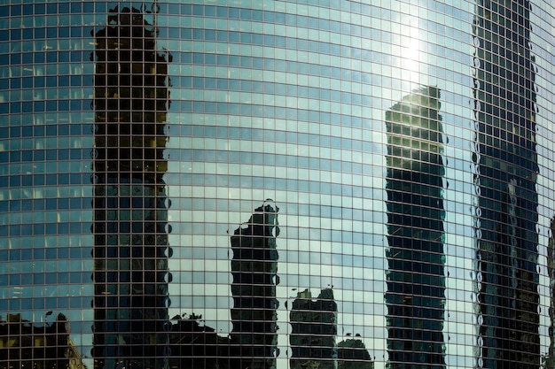 De stad wordt weerspiegeld in het glas van een wolkenkrabber bij zonsondergang