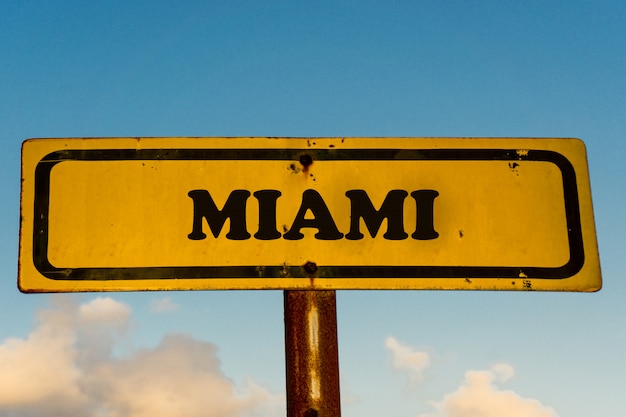 De stads oud geel teken van Miami met blauwe hemel