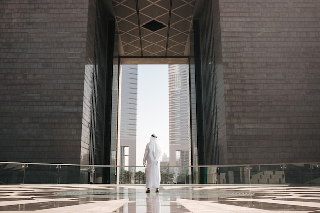 Foto de stedelijke levensstijl van de emiraten in de grote stad met een arabische investeerder die de stad in het golfland bekijkt.