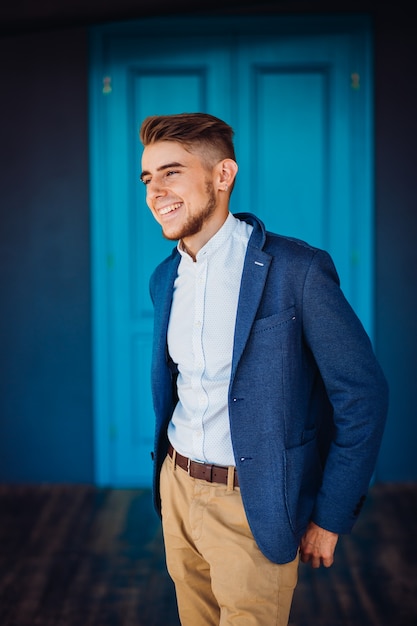 De stijlvolle jongen staat in de kamer