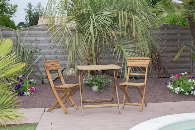 De stoelen en tafel in een houten terras