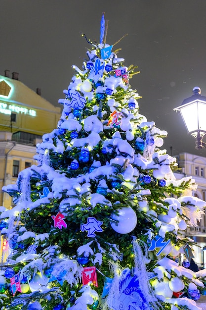 De straten van de stad versierd met kerstbomen en slingers tijdens oudejaarsavond De sneeuwstorm