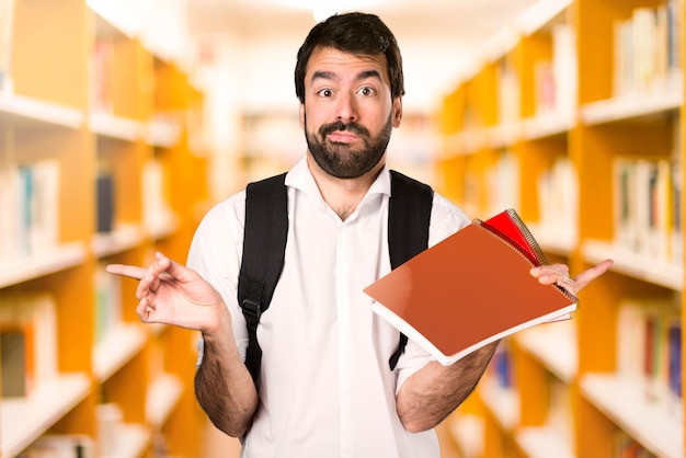 De studentenmens die aan de lateralen richten die twijfels hebben defocused bibliotheek