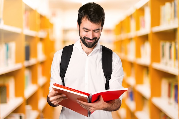 De studentenmens met notitieboekjes defocused bibliotheek