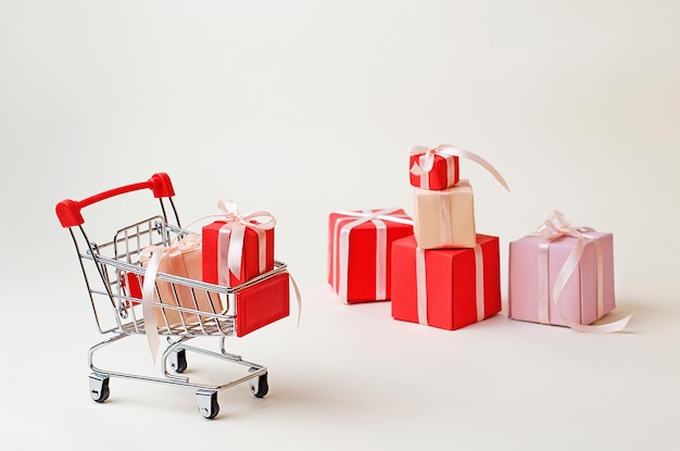 De supermarktkar is gevuld met rode kerstcadeaus