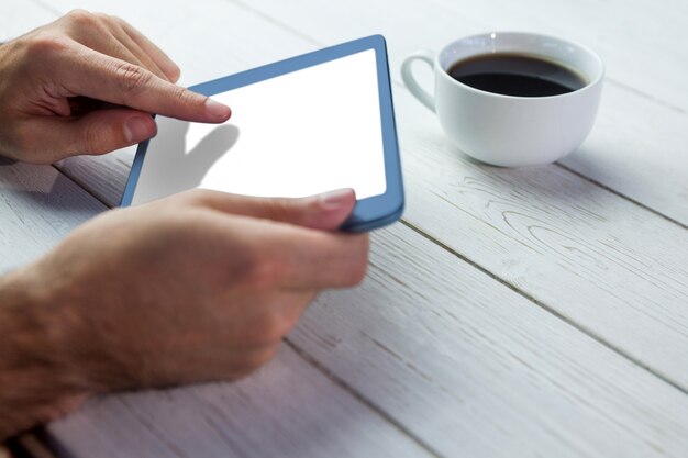 De tablet van de persoonsholding op houten bureau