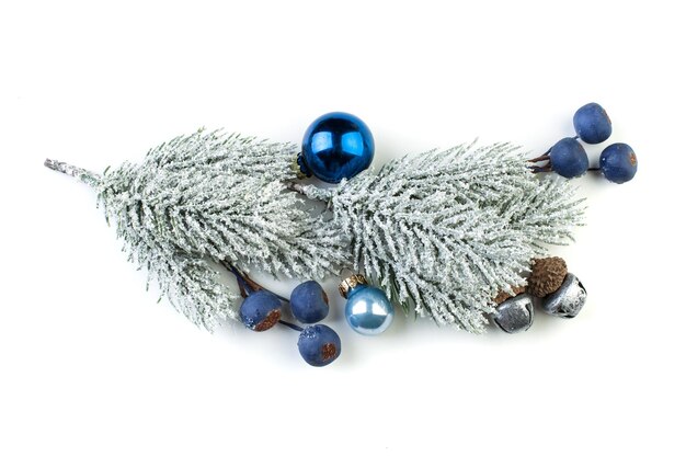 De tak van de Kerstmisspar met zilveren snuisterijen blauwe bessen en andere ornamenten die op wit worden geïsoleerd