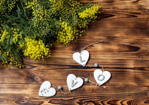 De takken van een mimosa op een houten tafel