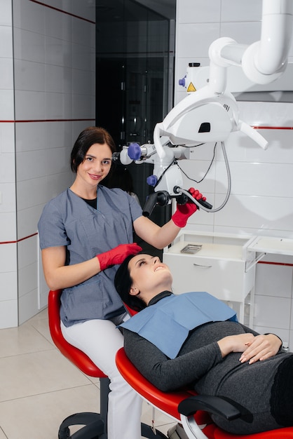 De tandarts kijkt door een microscoop en voert een operatie uit bij de patiënt