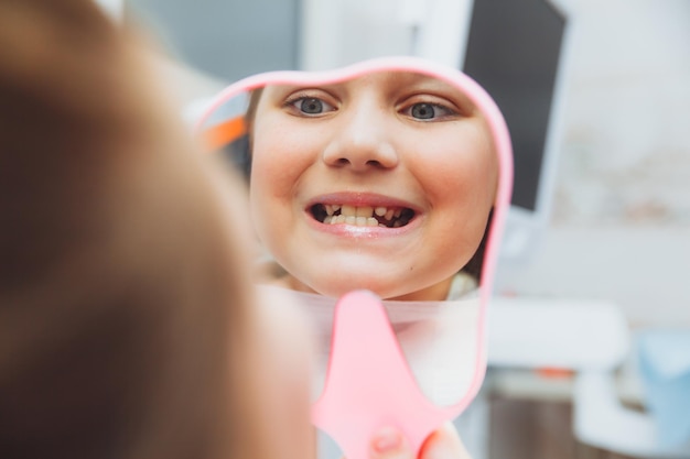 De tandarts onderzoekt de tanden van een jongen van 13 jaar oud in de kliniek pediatrische tandheelkunde