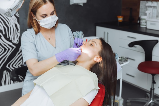 De tandarts onderzoekt de tanden van een vrouwelijke patiënt close-up moderne tandheelkunde