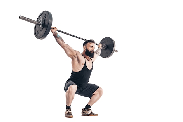 De techniek van het doen van een oefening van deadlift met een halter van een gespierde, sterke, getatoeëerde, bebaarde sportman