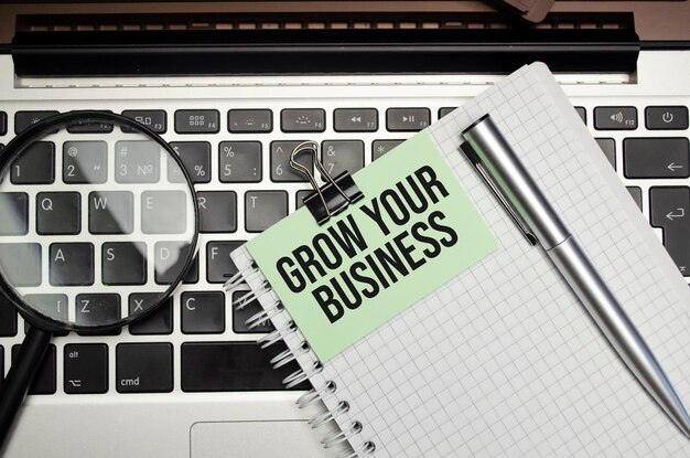 De tekst GROW YOUR BUSINESS verschijnt achter gescheurd bruin papier Hoge kwaliteit foto