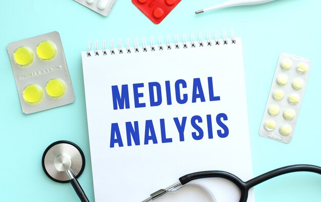 De tekst medische analyse is geschreven in een notitieboekje dat naast het stethoscoopmedicijn ligt op ab