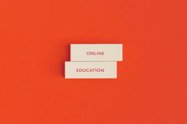 De tekst "Online onderwijs" op op houten blokken op gekleurde achtergrond.