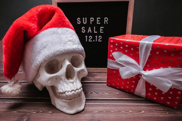 De tekst van de verkoop 1212 op het letterbord met een geschenkdoos en een schedel in een kerstmanhoed Ontwerp om de winteruitverkoop aan het einde van het jaar te promoten