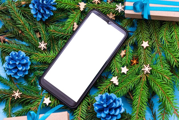 De telefoon ligt met Kerstmis op de takken van een boom.