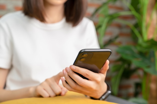 De telefoon van de de handholding van de vrouw op de bank bij huis.