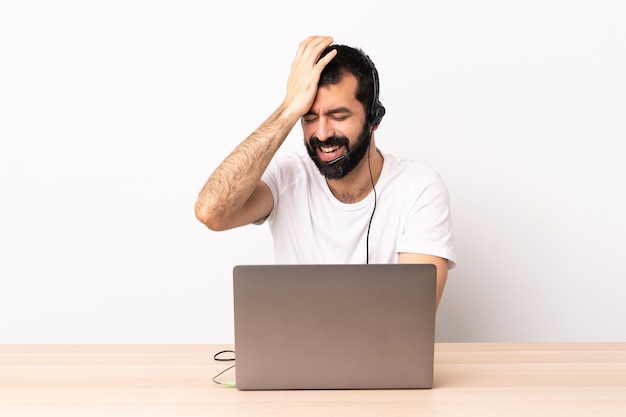 De telemarketeer Kaukasische mens die met een hoofdtelefoon en met laptop werkt heeft iets gerealiseerd en de oplossing voorgenomen