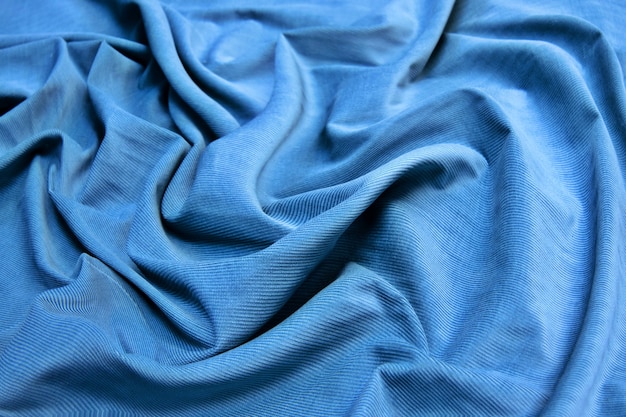 De textuur van de corduroy blauwe stof. Abstracte achtergrond van natuurlijke katoenen stof.