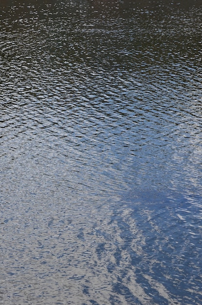 De textuur van donker rivierwater onder invloed van wind