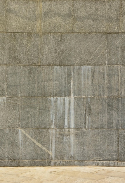 De textuur van een muur van grote granieten tegels die bedekt zijn met witte strepen wanneer ze worden blootgesteld aan