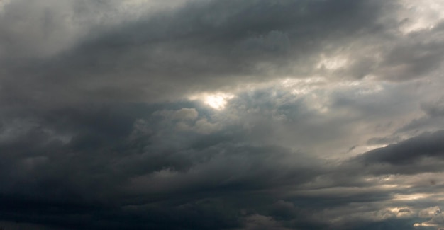 De textuur van een sombere wolk tegen de achtergrond van de doordringende zon voor de regen in de frisse lucht Zomer lente regenweer