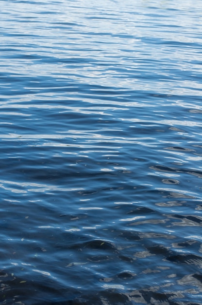 De textuur van het wateroppervlak is een rijke blauwe kleur in een verticale positie