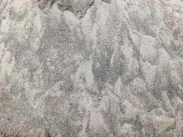 Foto de textuur van het zand is van een vuile vuile grijze en witte textuur