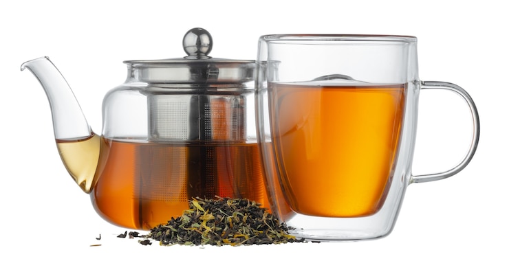 Foto de theepot van het glas en glaskop met thee op wit wordt geïsoleerd dat