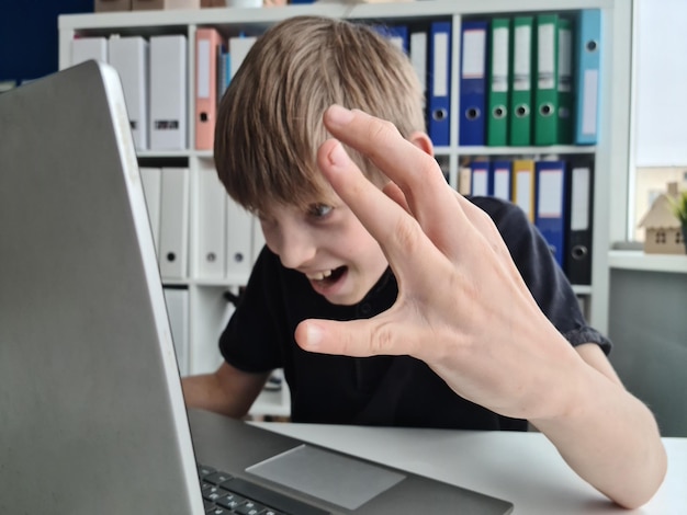 De tiener is gefrustreerd en schreeuwt naar het laptopscherm