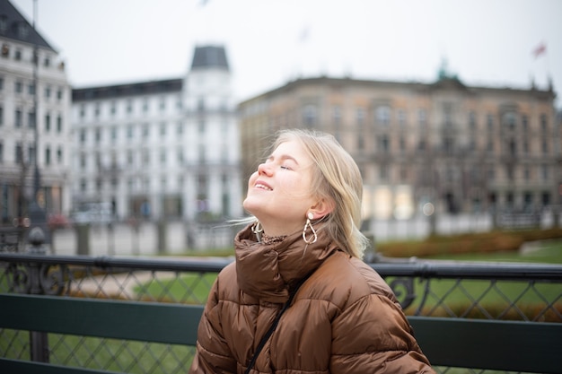 De tienervrouw heft haar hoofd op en sluit haar ogen