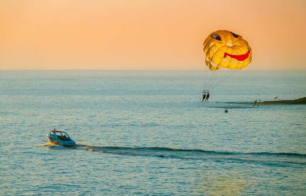 De toeristen genieten van parasailing op het strand